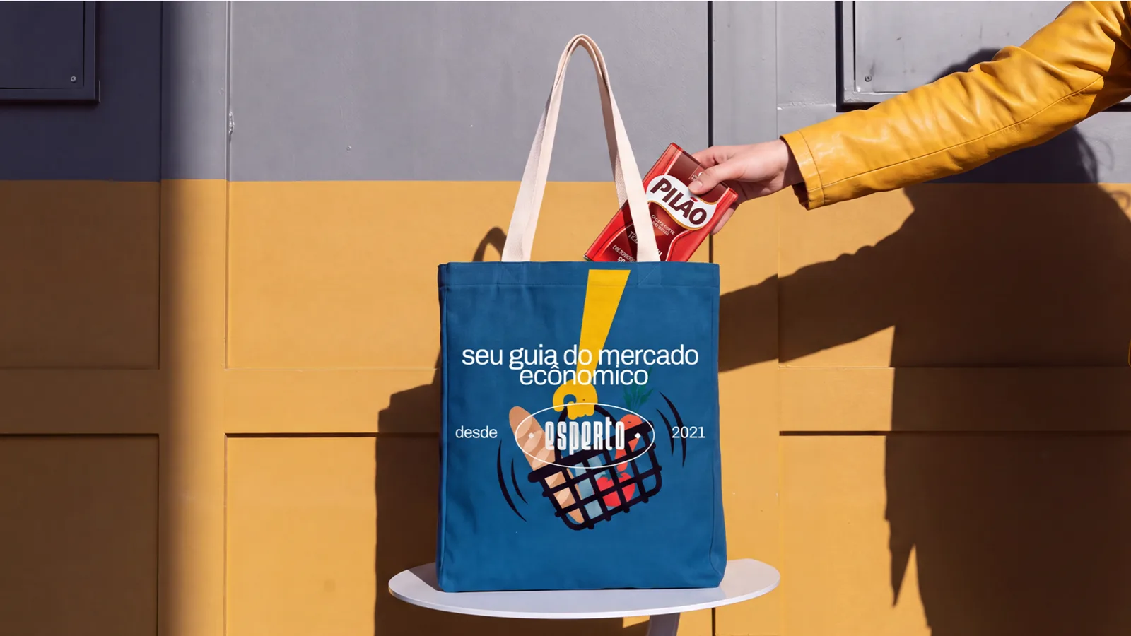 Bag azul esperto sobre uma mesa, recebendo um pacote de café